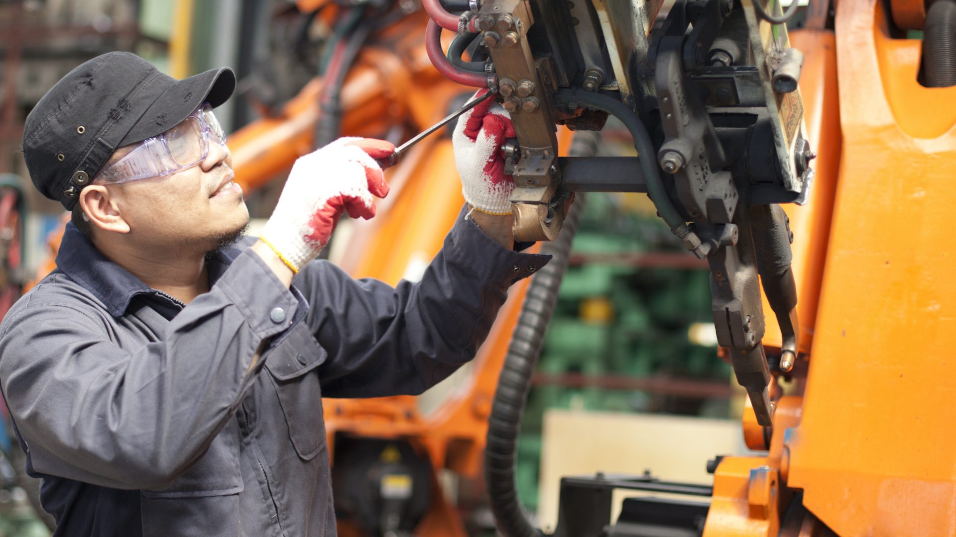 Repairman in factory Mechanic repairing a robot machine
